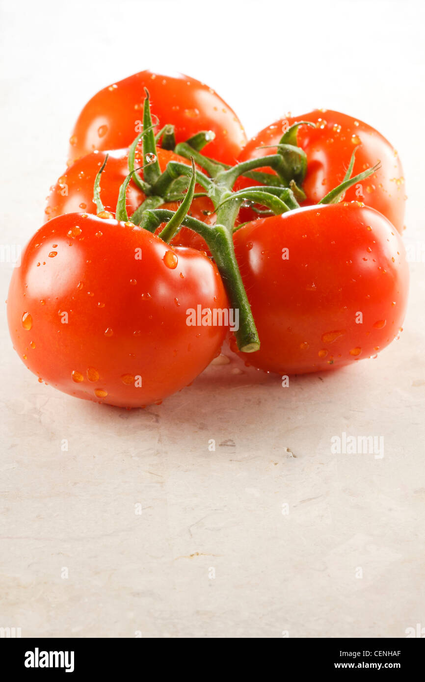 Pomodori a grappolo con goccioline di acqua Foto Stock