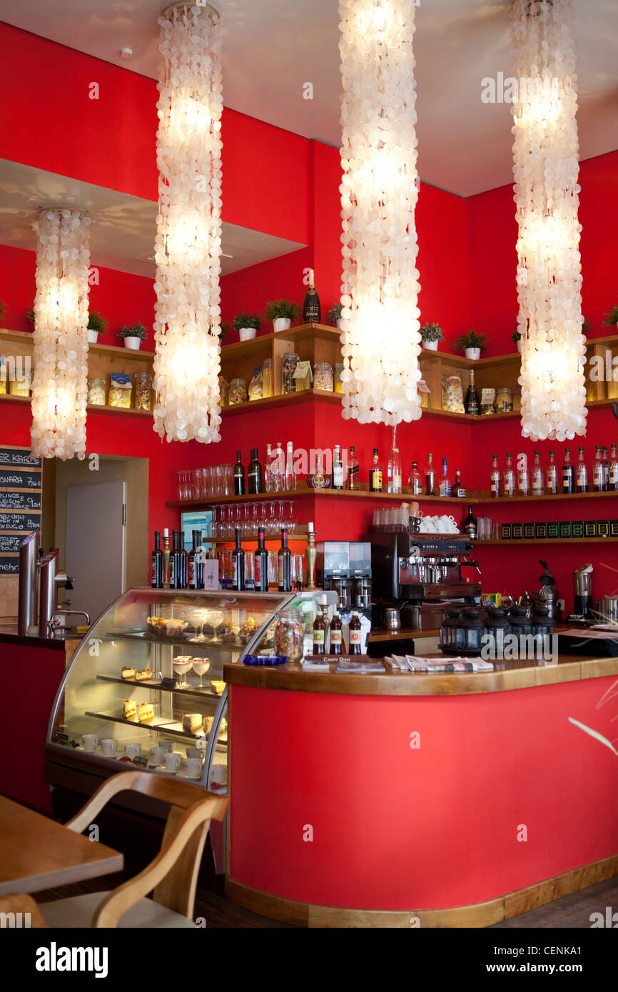 Un moderno bar interno in colore rosso con lampadari di cristallo Foto Stock