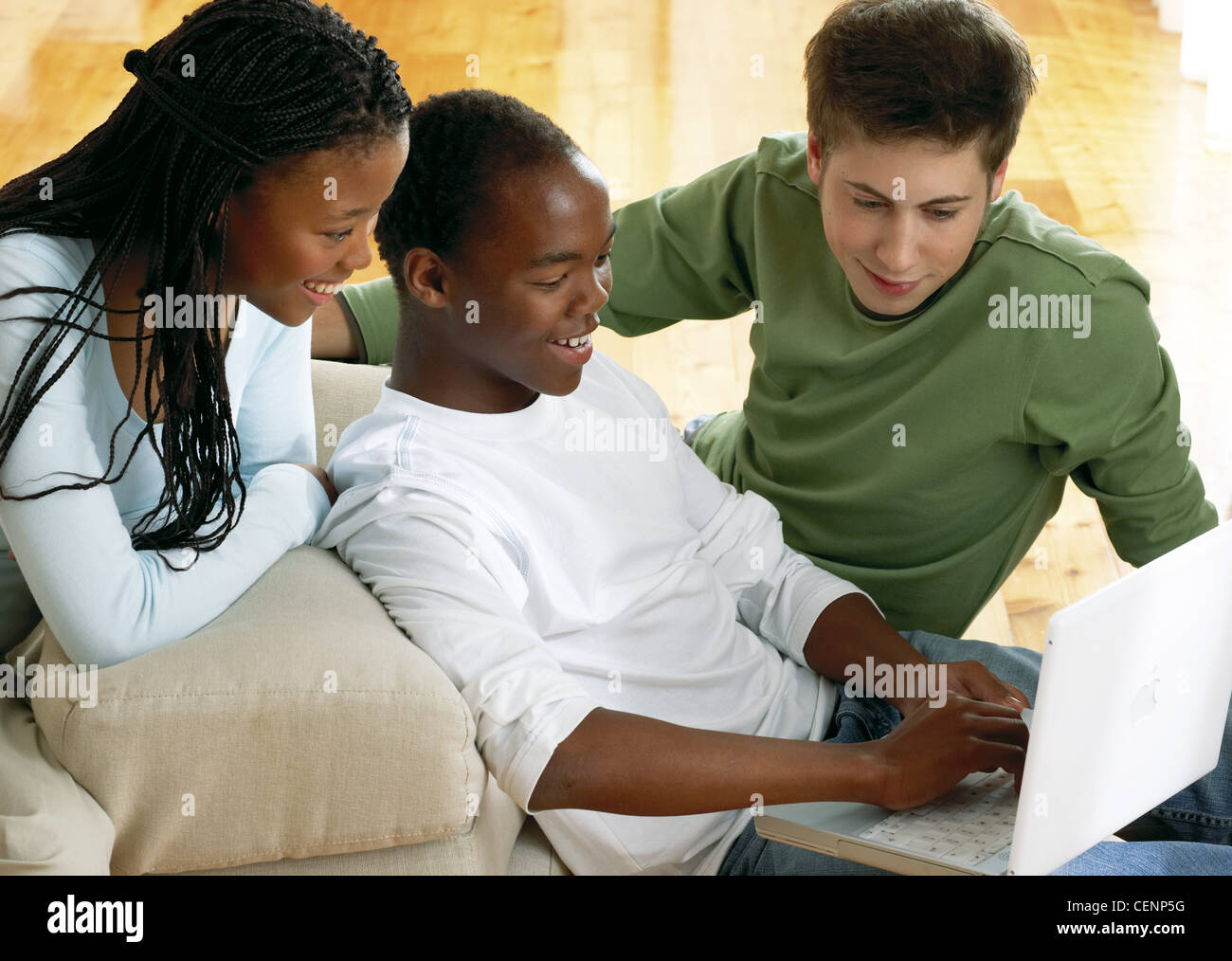 Tre adolescenti seduti insieme guardando un laptop Boy corti capelli neri indossando un bianco e maniche lunghe, ragazza lungo nero Foto Stock