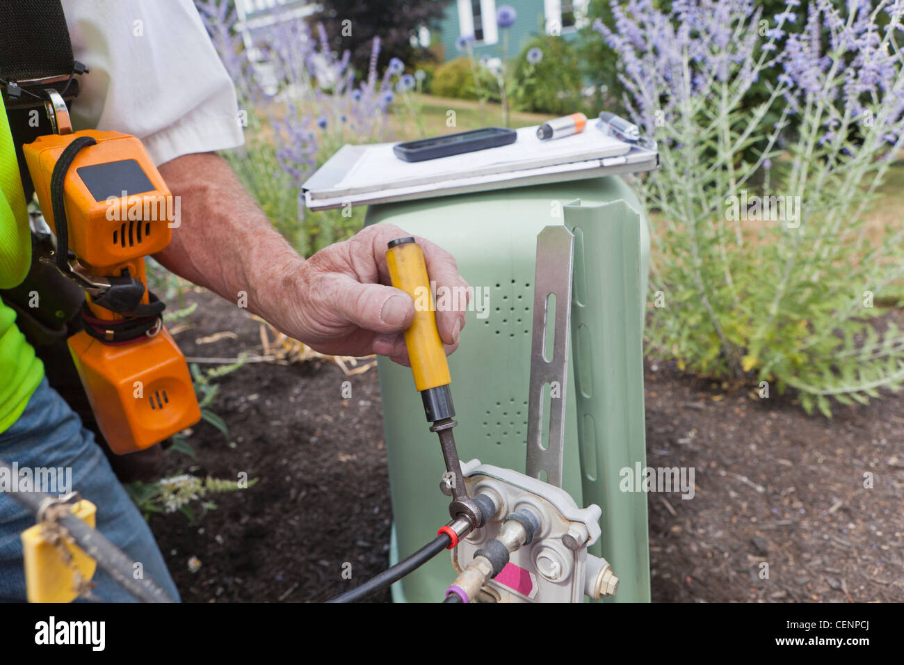 Lavoratore di comunicazioni via cavo di serraggio con la chiave Foto Stock
