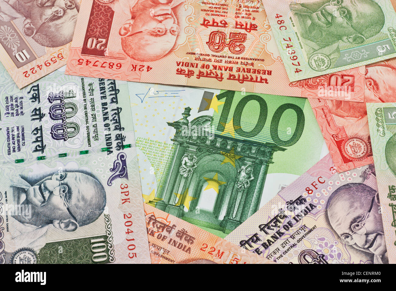 Molti rupia indiana fatture con il ritratto del Mahatma Gandhi affiancati. Al centro si trova un Euro 100 bill Foto Stock