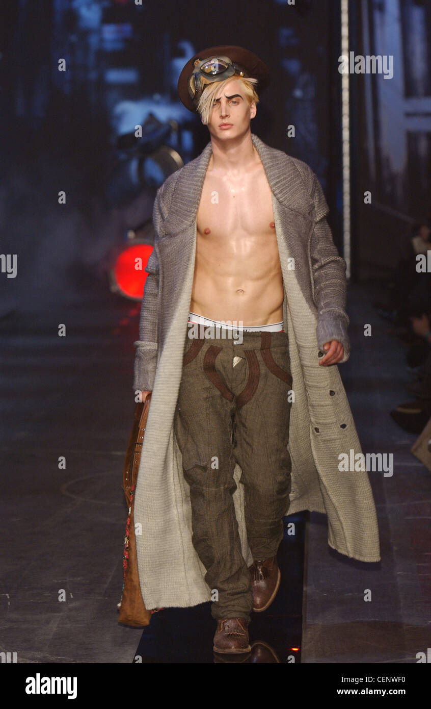 John Galliano pronto a indossare abbigliamento uomo Parigi A W Shirtless blonde modello maschile che indossa una piena lunghezza cappotto grigio verde scuro Foto stock Alamy