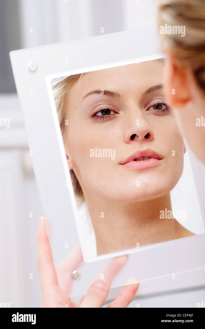 Femmina guardando il suo riflesso in uno specchio, Foto Stock