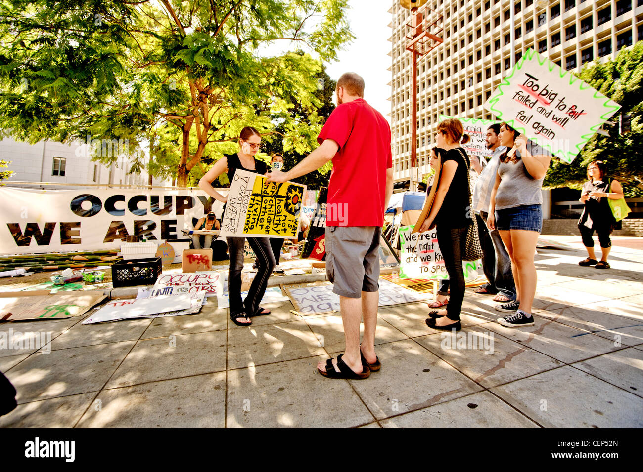 I manifestanti mostrano nuovi segni che esprimono la We-Are-IL-99% anti-capitalismo sentimenti di occupare Wall Street presenza a Los Angeles Foto Stock