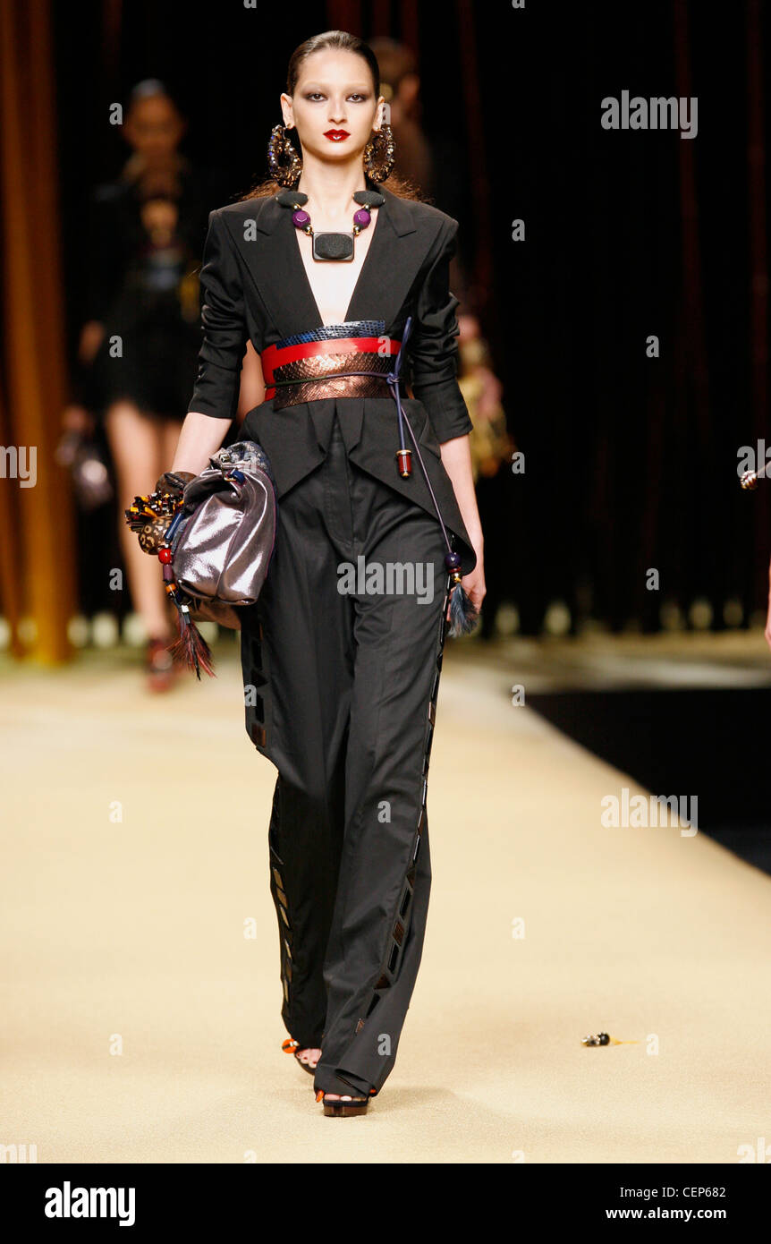 Modello di indossare una giacca nera maniche raccolte in precedenza i  gomiti, nero zampe larghi pantaloni tagliare fuori i lati, grande blu,  rosso e marrone Foto stock - Alamy