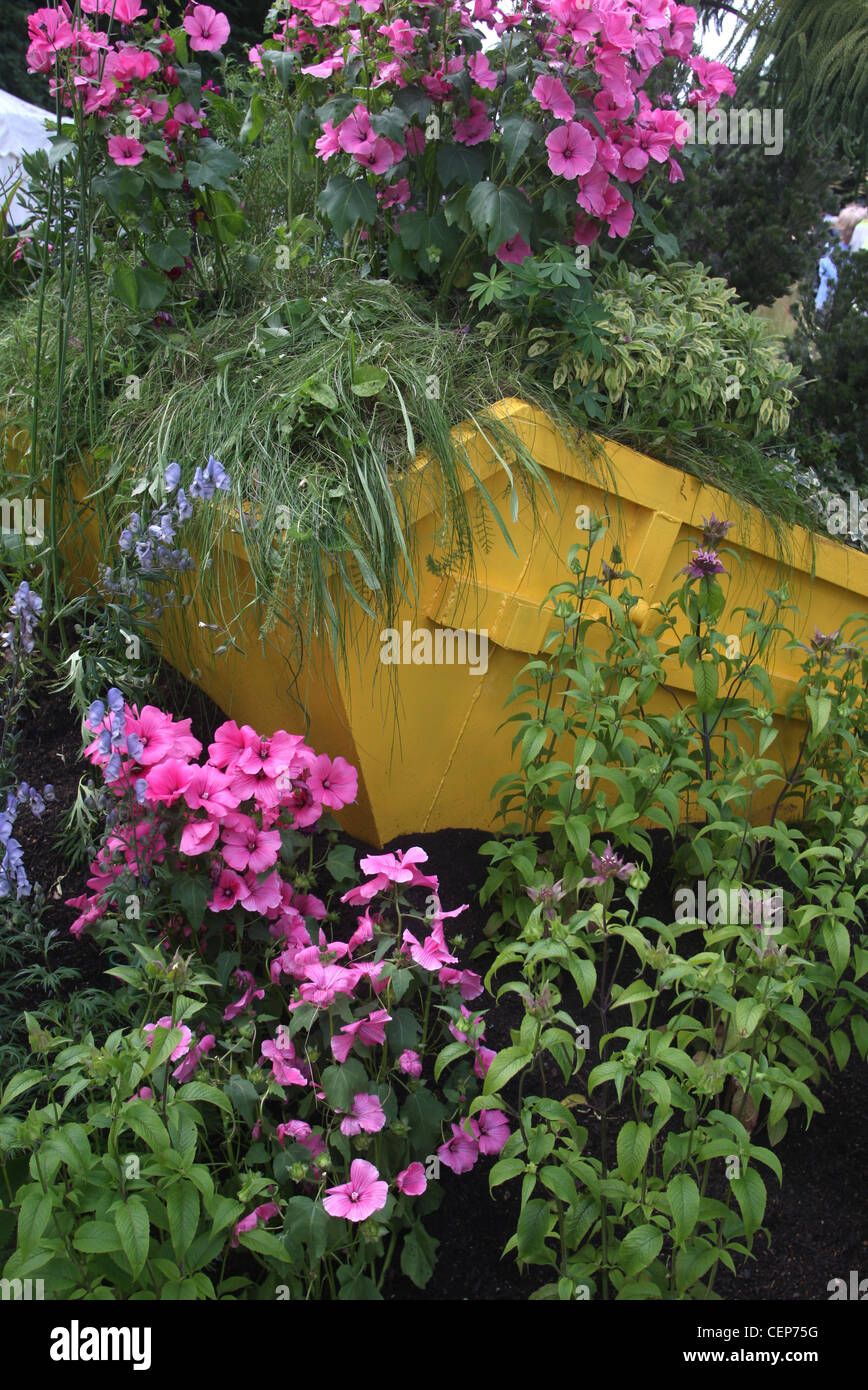 Dettaglio immagine di un giallo saltare varie erbe, piante e fiori piantati in e attorno ad esso con la guerriglia giardinaggio giardino Org Foto Stock