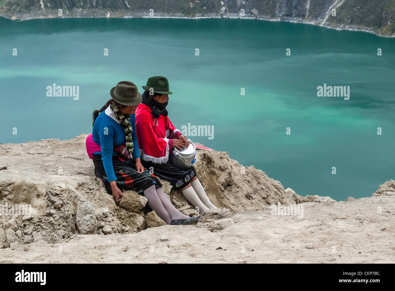 Due ecuadoriani indigeni donne indiane le guide di arresto per una pausa pranzo si affaccia sul Cratere del Quilotoa, Quilotoa, Ecuador. Foto Stock