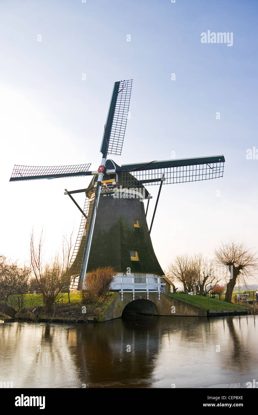 Mulino a vento olandese congelati paesaggio invernale in un pomeriggio soleggiato Foto Stock