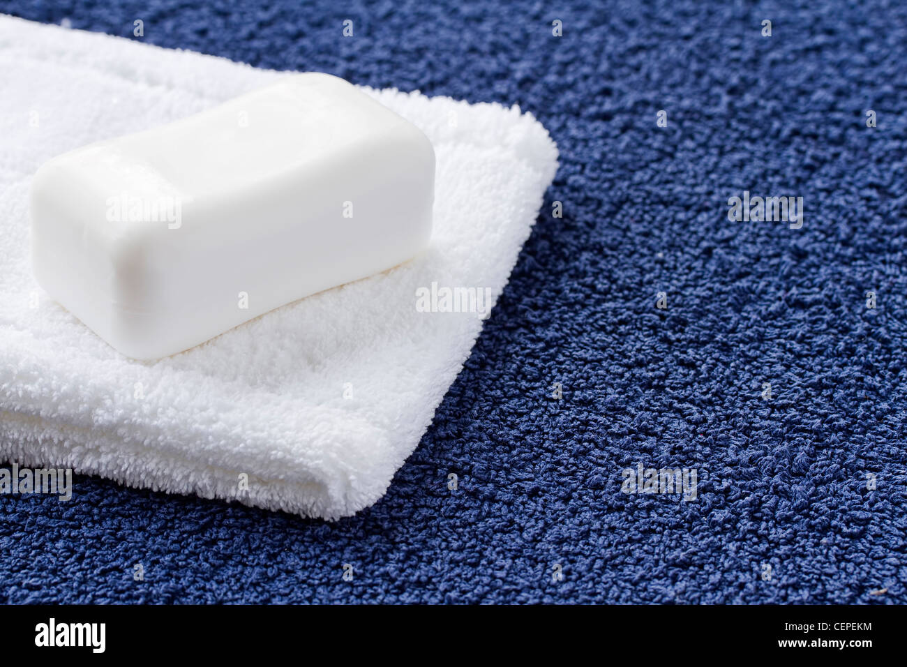 Barra di sapone bianco e toalhinha sul tovagliolo blu Foto Stock