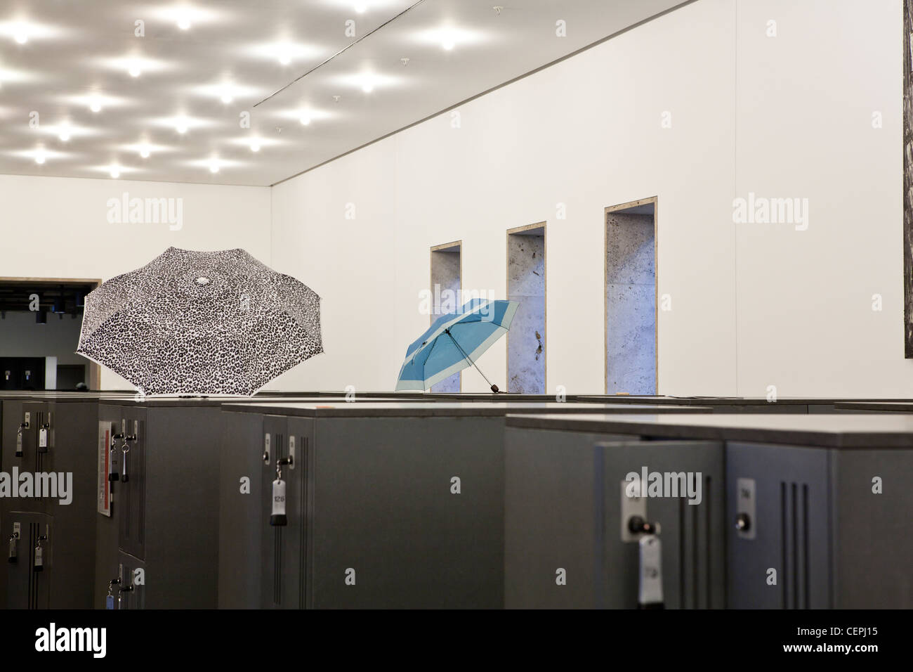 Ombrelloni lasciato sulla parte superiore di armadietti all'interno di una biblioteca universitaria. Foto Stock