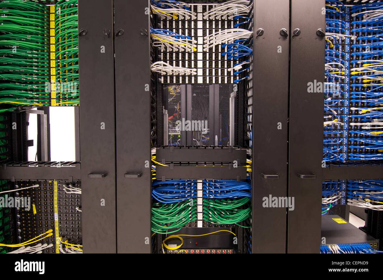 Cavi Ethernet e connettori femmina disposti ordinatamente in rack del server di un data center presso alcuni Hong Kong uffici. Foto Stock