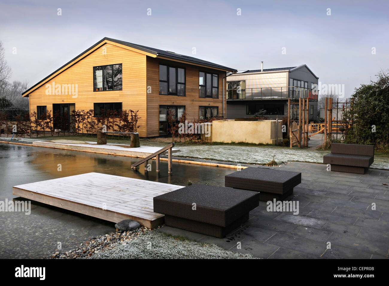 Una piscina naturale che ha ricoperto di ghiaccio in inverno a un auto costruire placcati in legno home UK Foto Stock