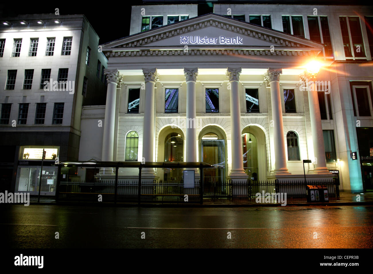 Il frontale illuminato di Ulster Bank di notte a Belfast. Foto Stock