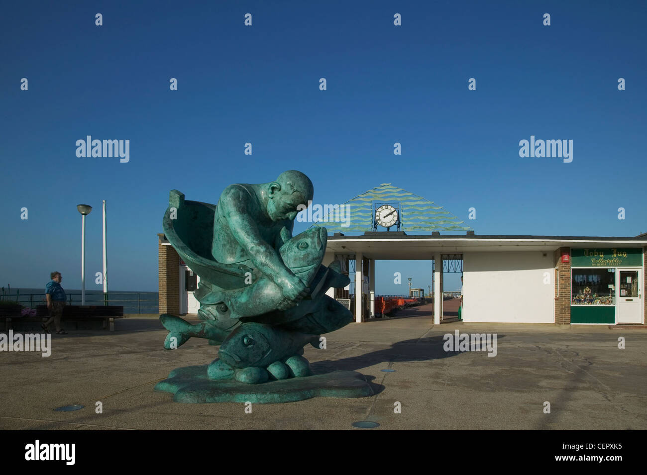 La statua di Alan Yates tenendo un gigantesco Sea bass intitolata "abbracciando il mare" da Jon Buck sulla trattativa Pier. Foto Stock