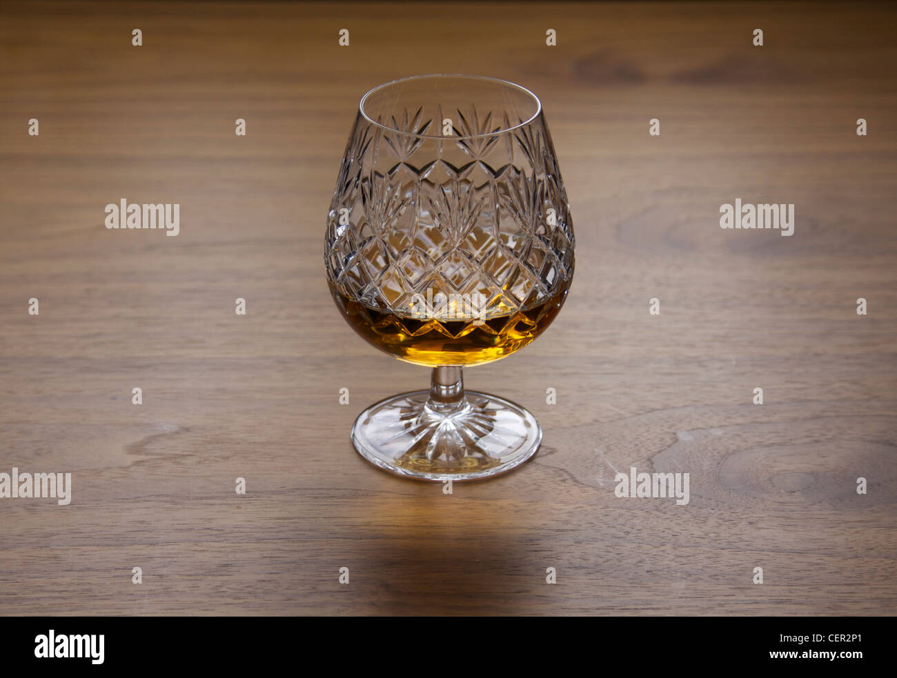 Brandy tradizionale fatta di vetro da tagliare cristallo con brandy o whisky whiskey con diamante modello dettaglio sul tavolo di legno Foto Stock