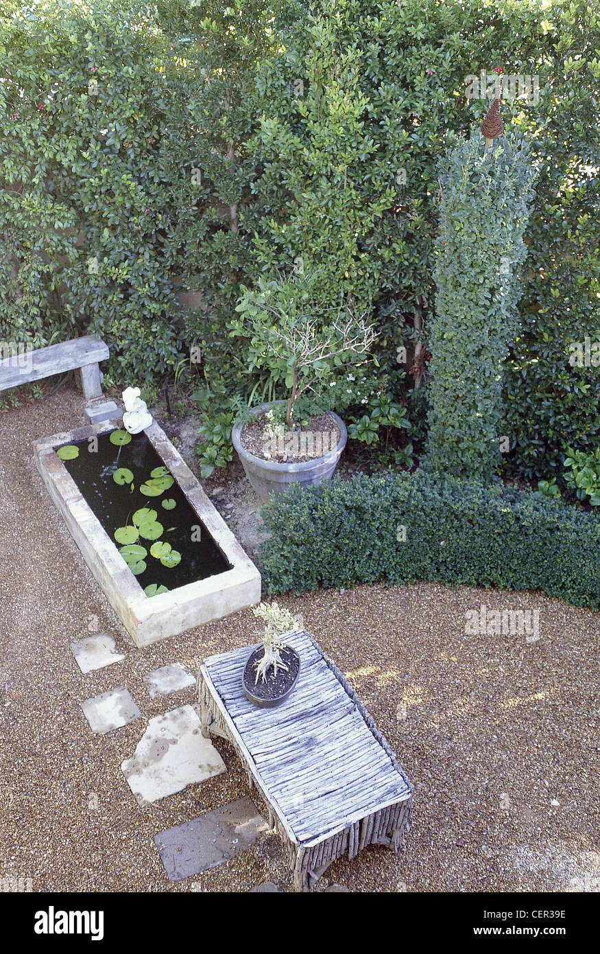 Piccoli giardini siepe giardino alberato rifilato curvo privet hedge e hedge rifilato in alta colonna bordo rotondo di ghiaia pavimentazione area Foto Stock