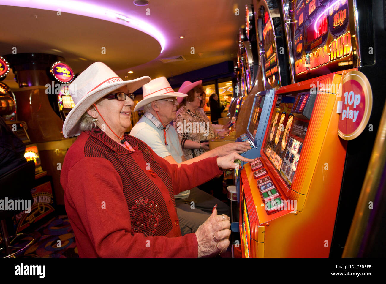 Persone che giocano a frutta e slot machines in una Mecca Bingo club di Roma Anagnina, Sandwell, West Midlands. Foto Stock