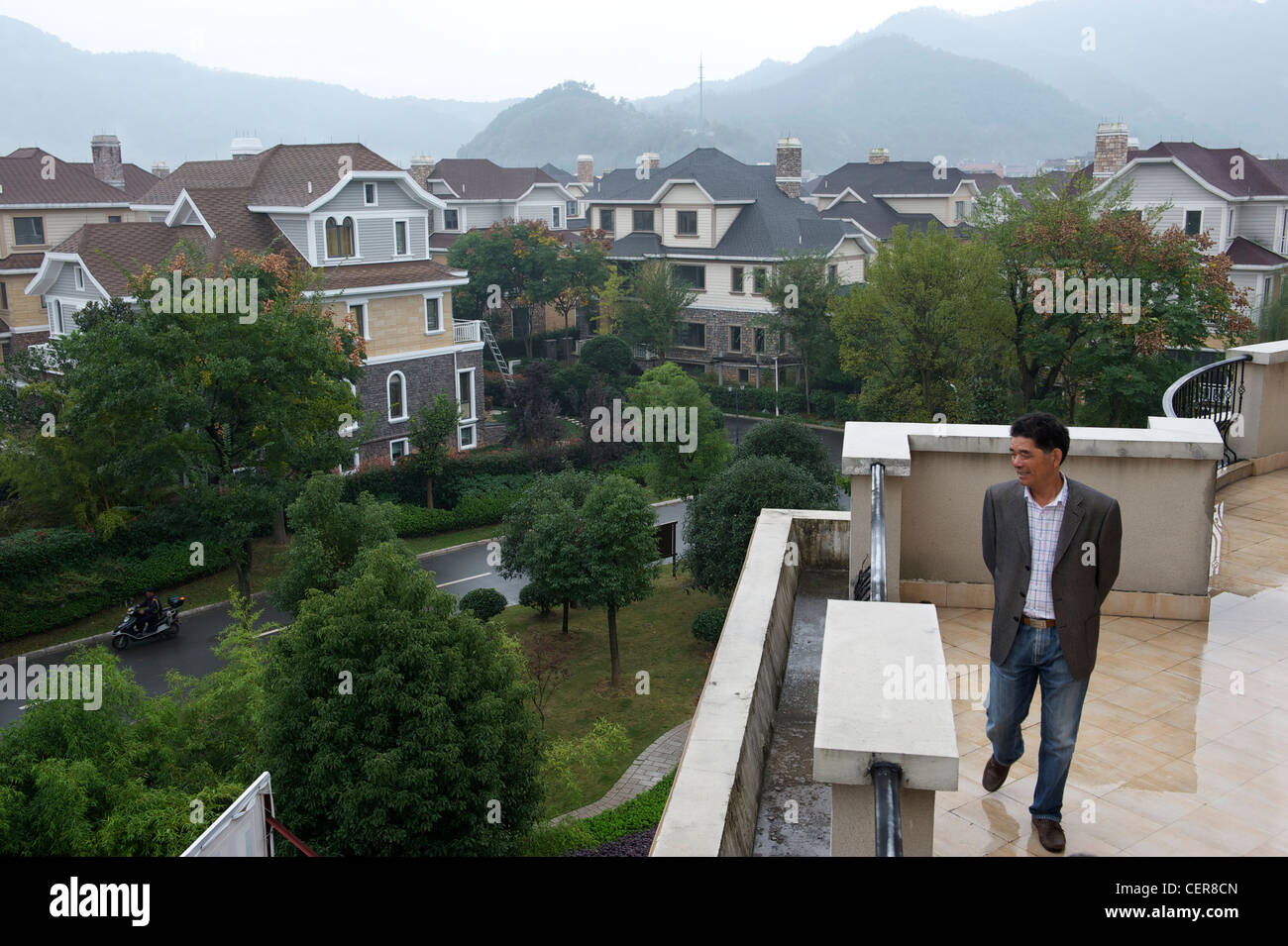 Hu Jishen, presidente del gruppo Xingyue, guarda a lussuose ville sviluppato da Xingyue in Yongkang, Zhejiang, Cina. Foto Stock