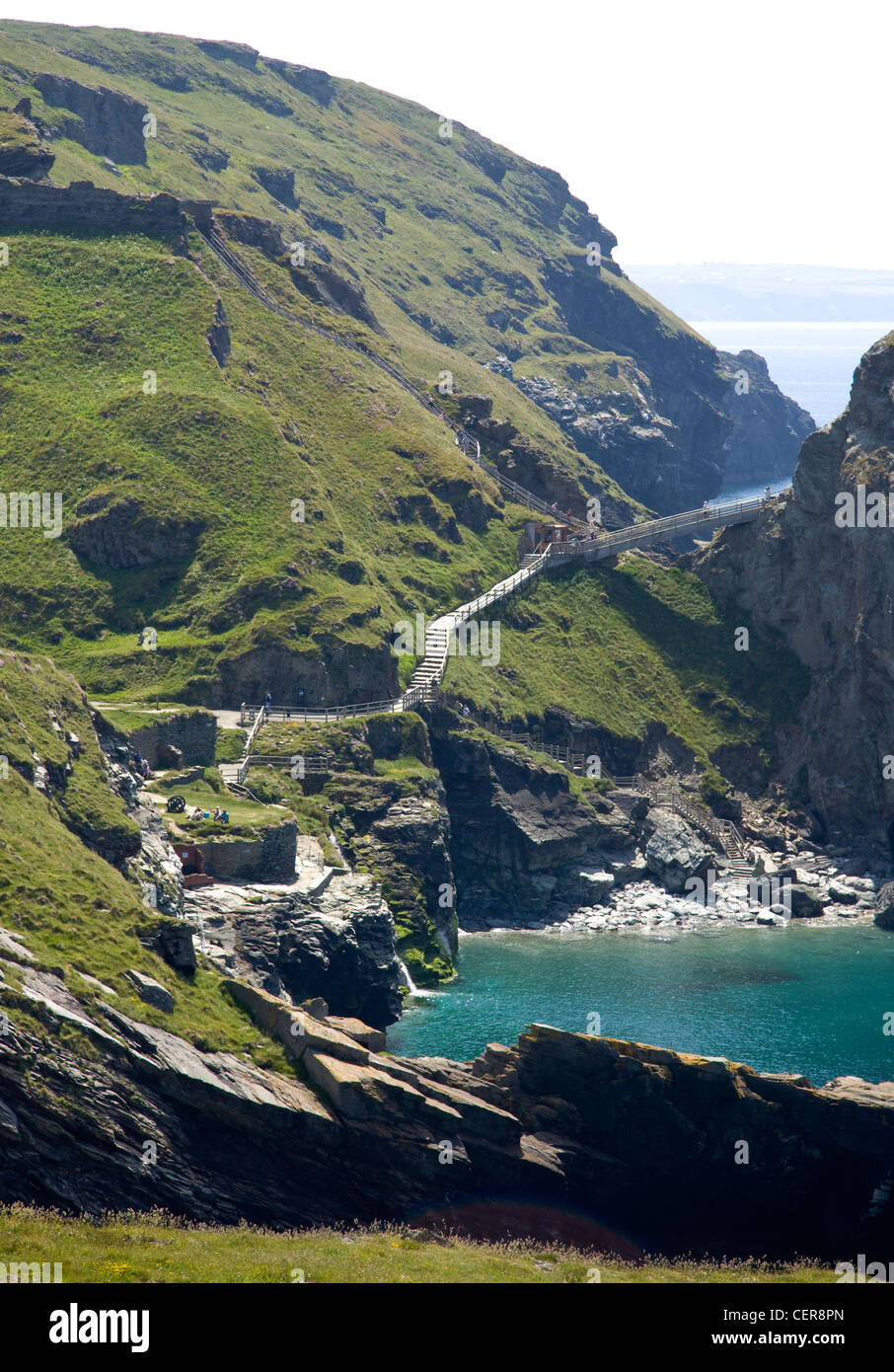 Sentiero passi e ponte che conduce alla testa di Tintagel, il sito del castello di Tintagel associato con la leggenda di Re Artù. Foto Stock