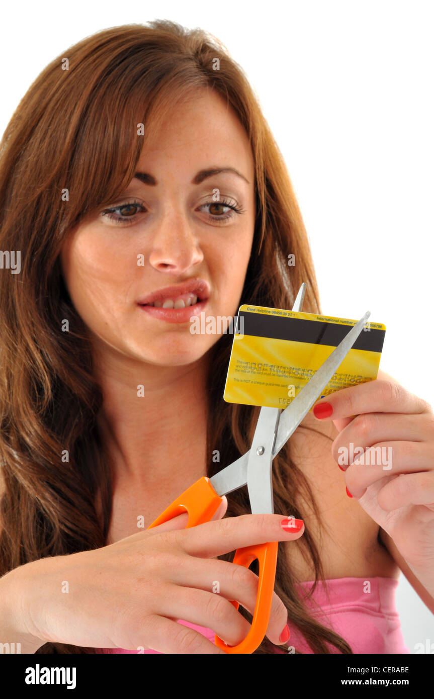 Carta di credito, donna taglio la sua carta di credito con le forbici Foto Stock