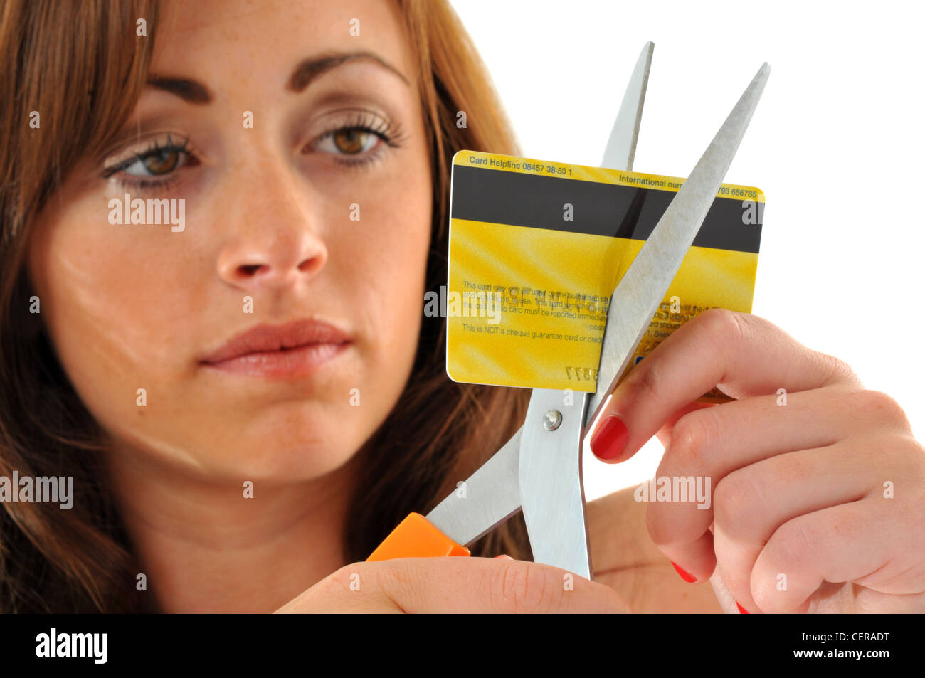 Carta di credito, donna taglio la sua carta di credito con le forbici Foto Stock