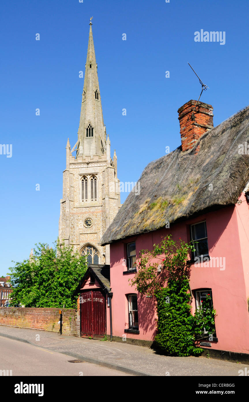 Un cottage con tetto di paglia e Thaxted chiesa, una delle più belle chiese parrocchiali nel paese. Foto Stock