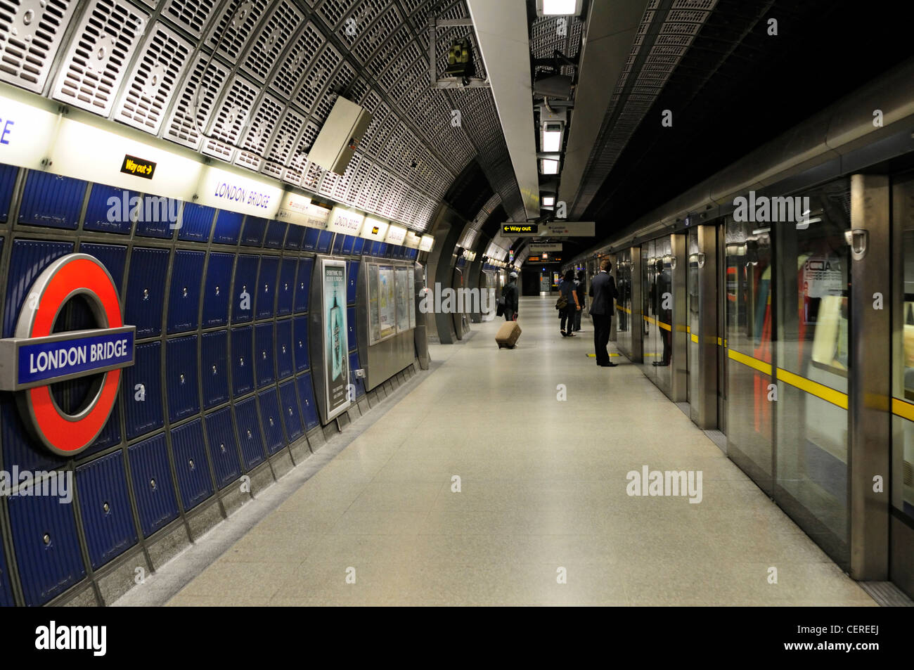 I passeggeri in attesa di salire a bordo di un treno di tubo su una linea Jubilee piattaforma a London Bridge Stazione della Metropolitana. Foto Stock