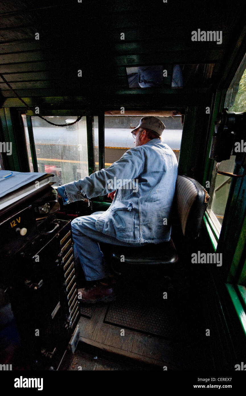 Un treno ingegnere alla guida di una antica locomotiva diesel sul lago Whatcom percorso ferroviario nel nord-ovest dello Stato di Washington. Foto Stock