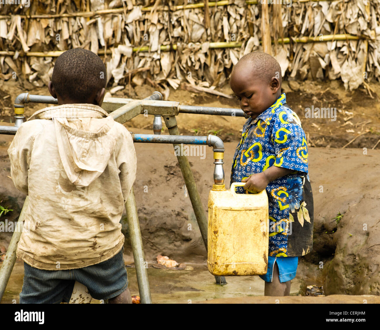 26/01/2012: giovani ragazzi scarica l'acqua dai rubinetti a un IDP camp presso il villaggio di Karonja nella periferia di Masisi . Molte famiglie hanno istituito rifugi di fortuna nel villaggio di Karonja dove la cura funziona. Foto di Julie Edwards. Foto Stock