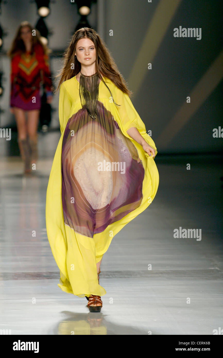 Etro Milano pronto a indossare Primavera Estate Brunette modello femminile i capelli dritti indossando un giallo kaftan viola la stampa batik un Foto Stock