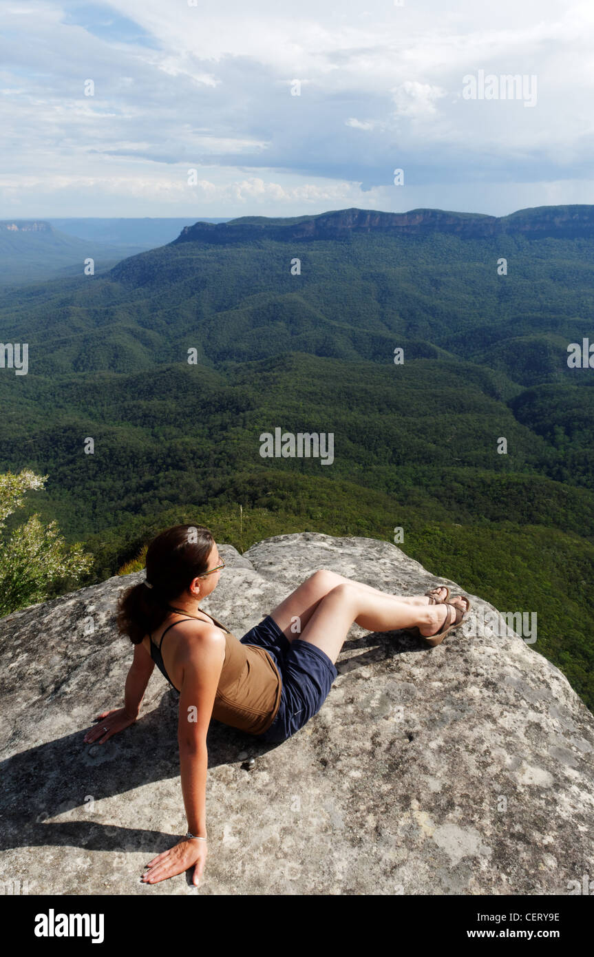 Una giovane donna che guarda oltre le montagne blu, Australia Foto Stock