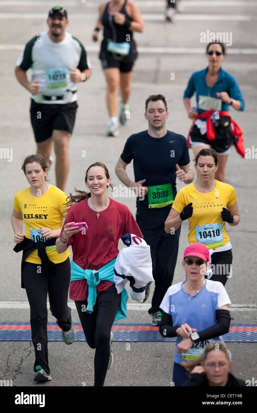 Gli atleti celebrare come più di 18.000 corridori pestate le strade del centro città di Austin per la maratona annuale gara Foto Stock