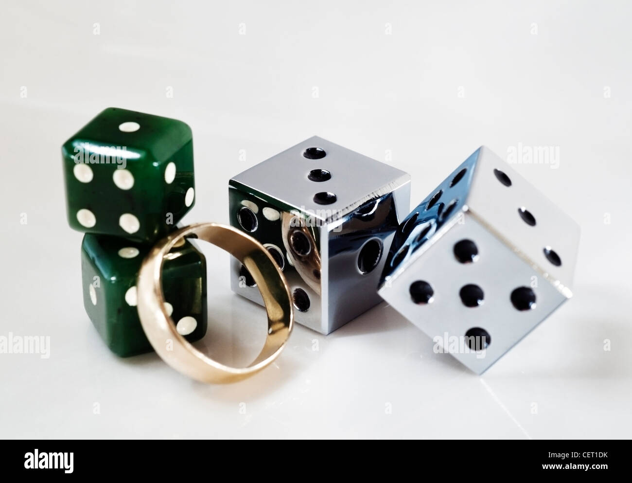 Chrome e jade dice con un oro anello di nozze Foto Stock