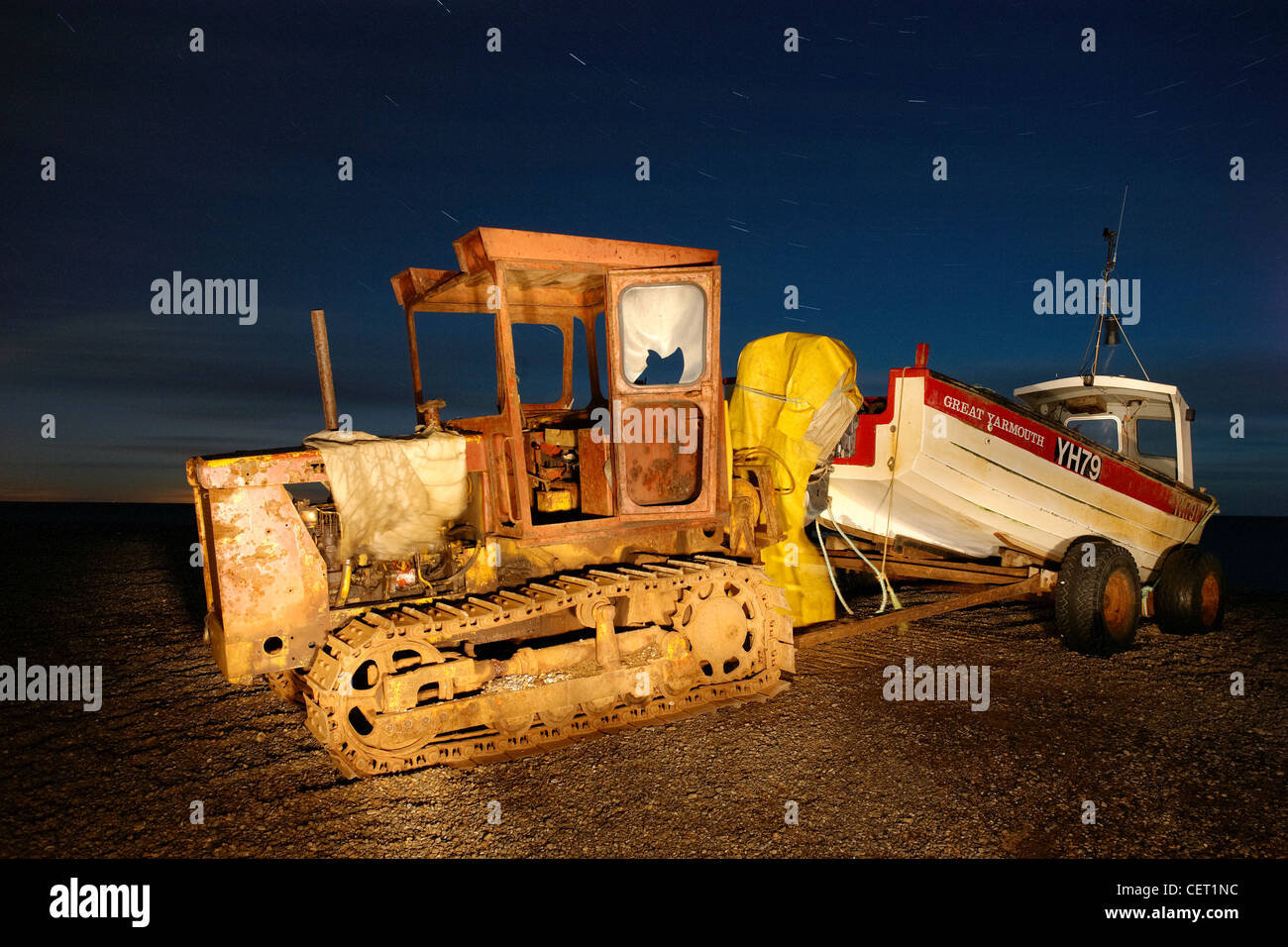 Un tempo di notte colpo di una barca da pesca attaccato ad un escavatore sulla costa a Weybourne. Foto Stock