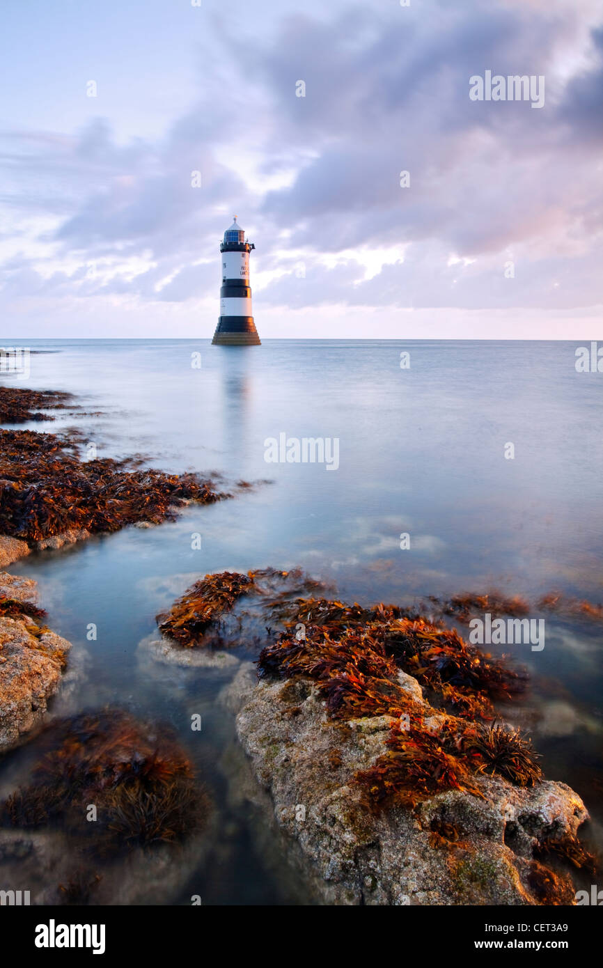 Una vista di Penmon Faro all'alba sulla costa di Anglesey nel Galles del Nord. Foto Stock