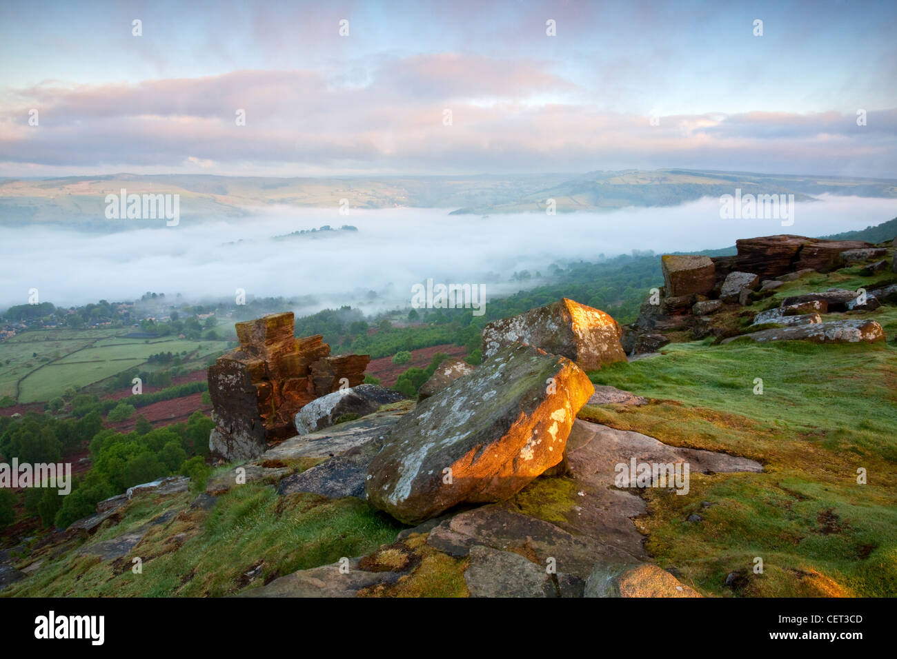 Foschia sopra il villaggio di Calver visto alla prima luce dal bordo Curbar nel Parco Nazionale di Peak District. Foto Stock