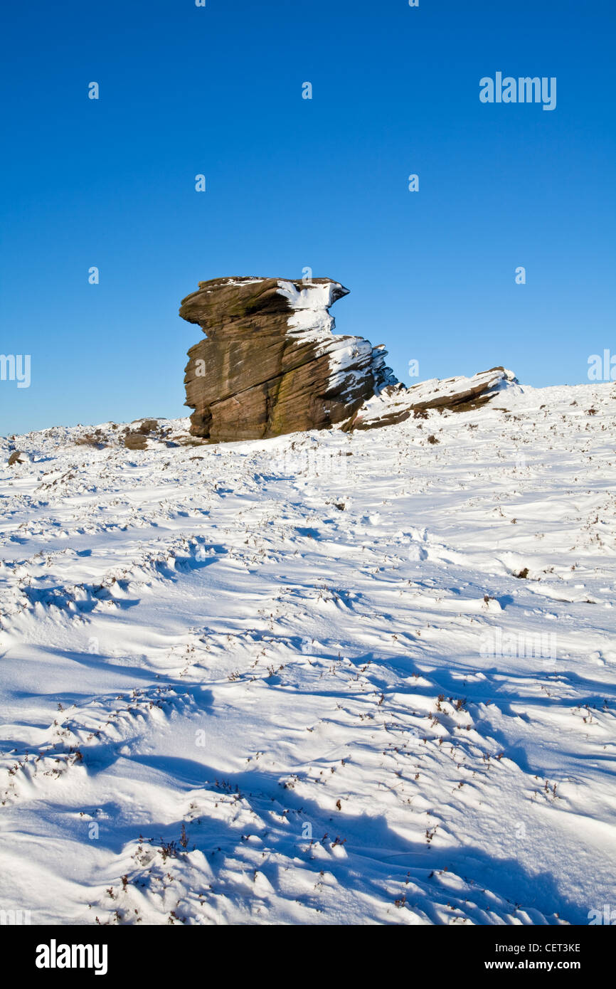 Sulla neve e madre circostante il tappo, una grande roccia gritstone formazione nel Parco Nazionale di Peak District. Foto Stock