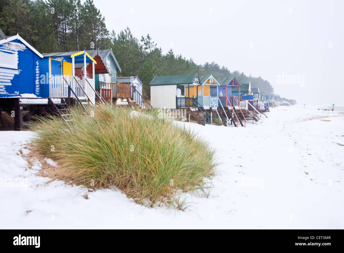 La famosa spiaggia colorata di capanne a Wells-next-mare a seguito nevicate invernali sulla costa di Norfolk. Foto Stock