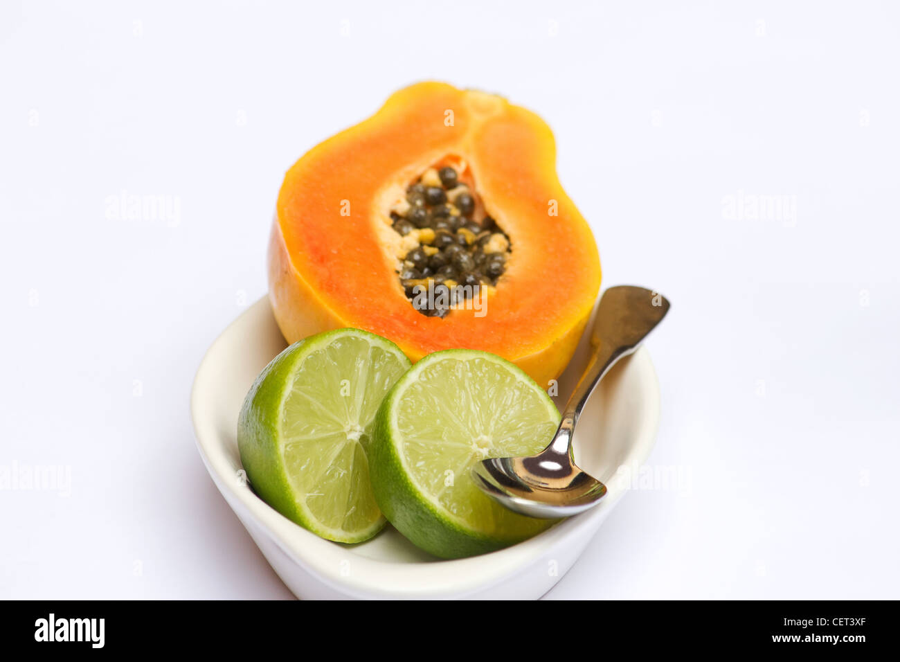 La papaia e calce su sfondo bianco Foto Stock