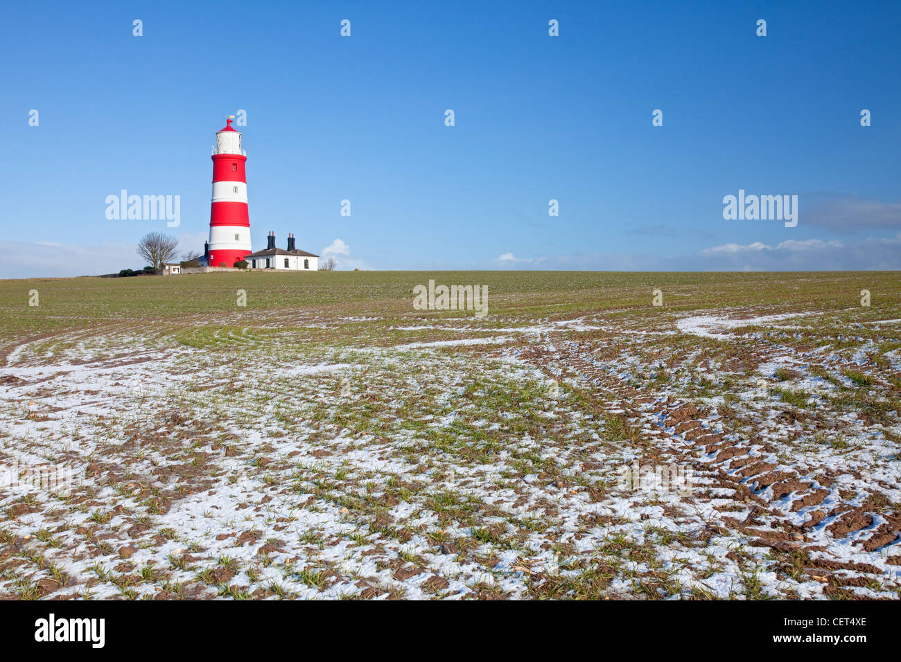 In inverno la neve in un campo da Happisburgh Lighthouse, il più antico faro di lavoro in East Anglia. Foto Stock