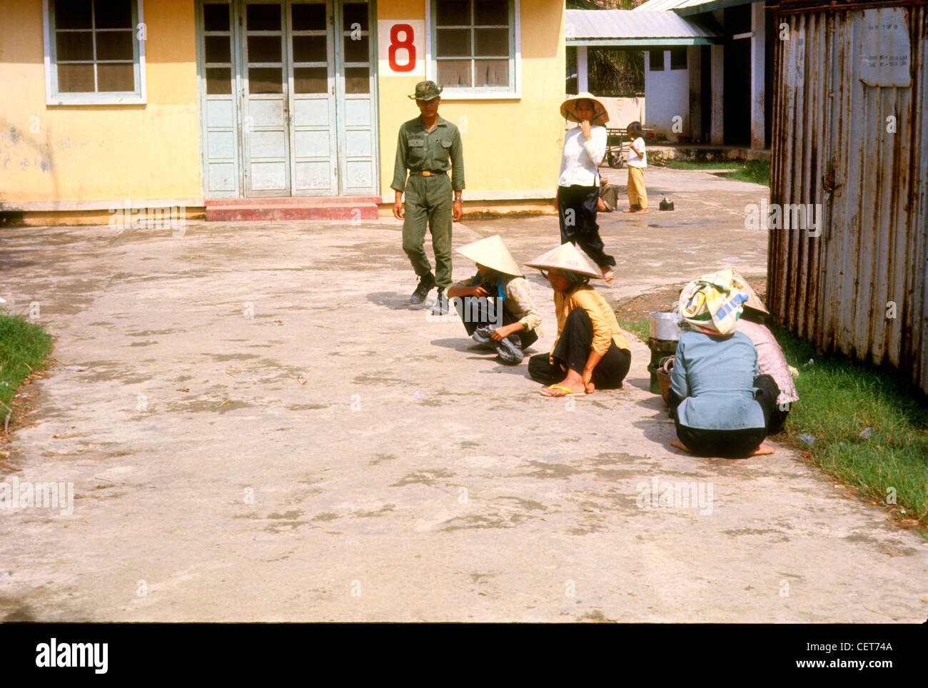 ARVN sud soldato vietnamita passando le donne che lavorano nel villaggio durante la Guerra del Vietnam. Foto Stock