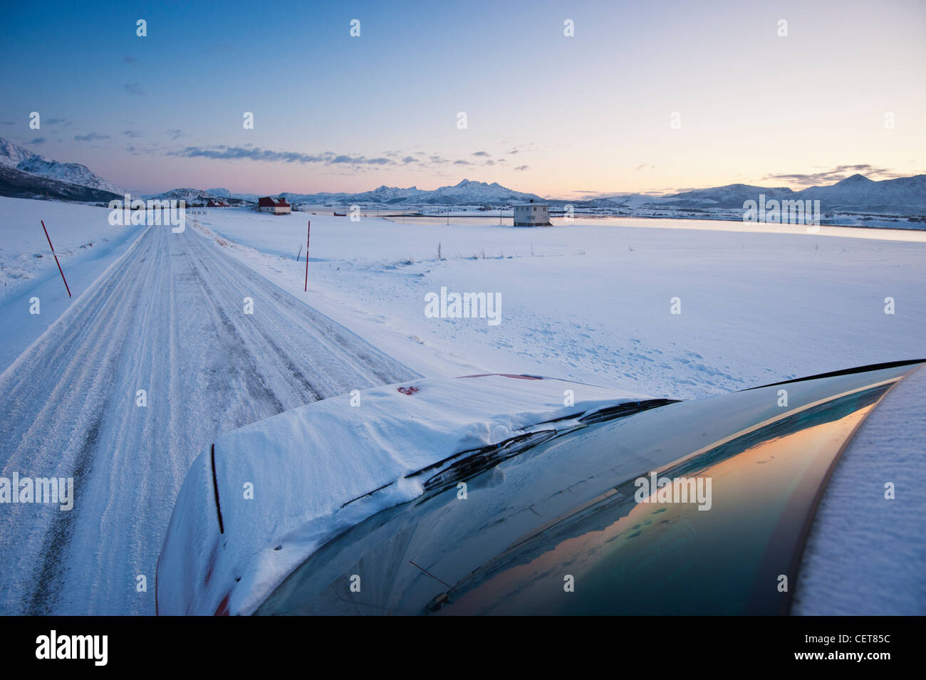 La parte anteriore della guida auto su strada in inverno con neve, Isole Lofoten in Norvegia Foto Stock