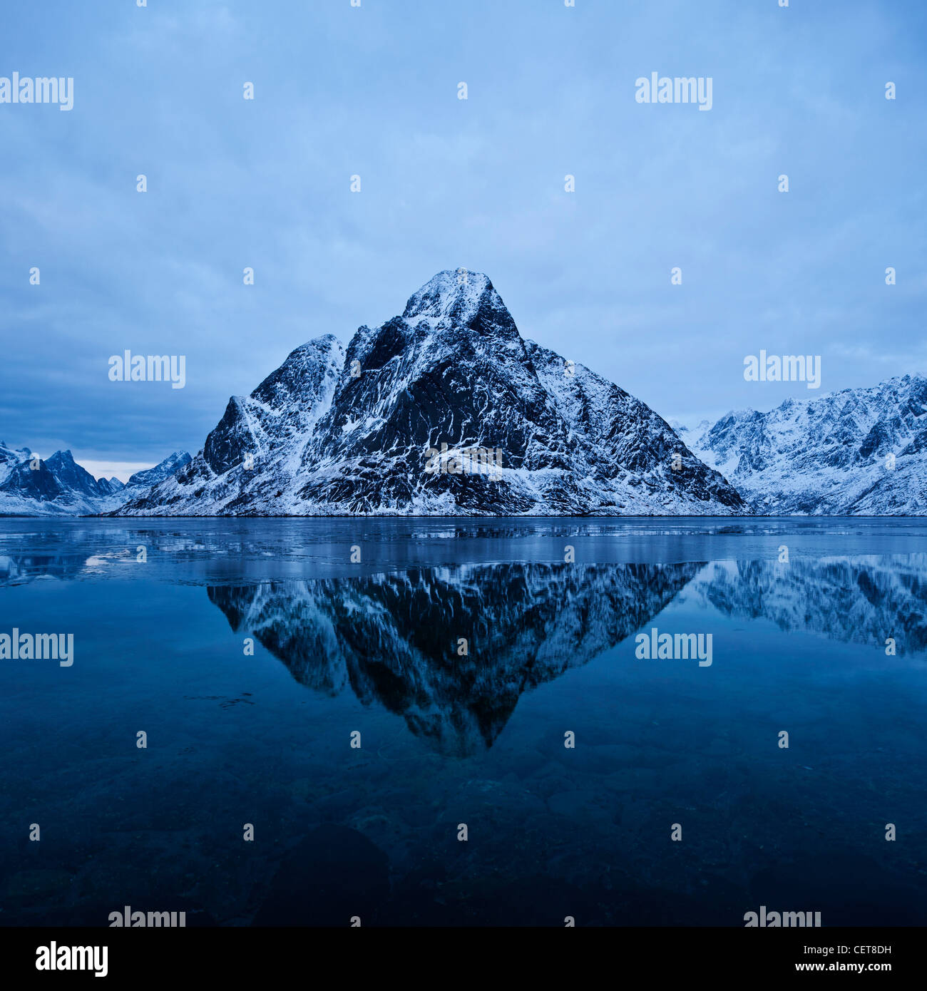 Olstind picco di montagna sorge dal fiordo, Reine, Isole Lofoten in Norvegia Foto Stock
