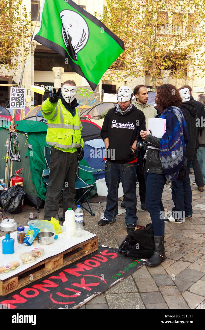 Un occupare Londra protester mostrano segno di pace permanente, mentre con altri manifestanti in mezzo alle tende di fronte St.la Cattedrale di San Paolo Foto Stock