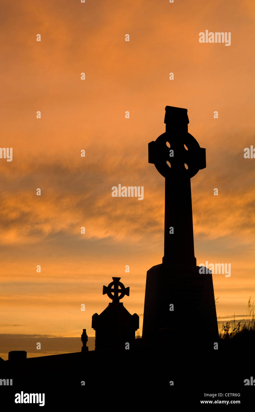 Croce celtica nel cimitero al tramonto Foto Stock