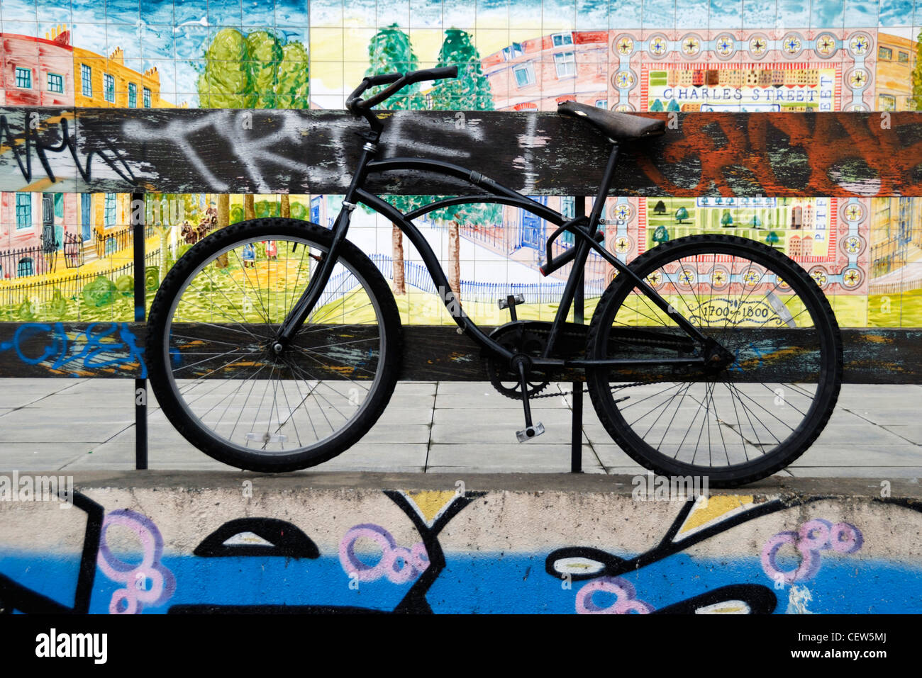 Una bicicletta contro uno sfondo di dipinti murali dipinti murali e grafitti, Hoxton, Londra, Inghilterra Foto Stock