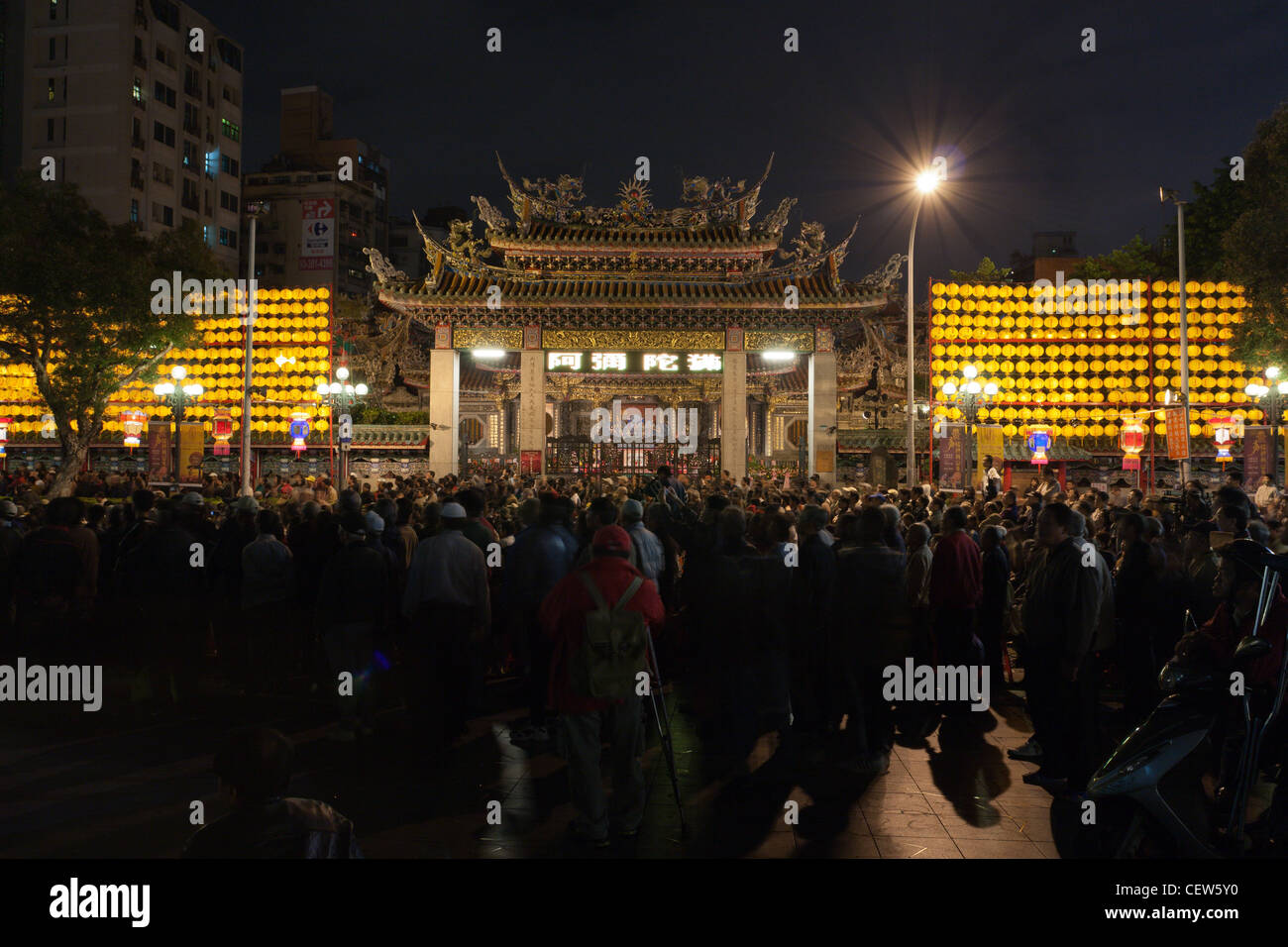 La folla si raccolgono intorno al Tempio Lungshan, storico buddista e il Tempio Taoista, durante la sua 270anniversario, visto di notte, Wanhua, Taipei, Taiwan Foto Stock