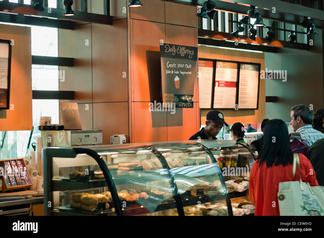 Persone in attesa per la tazza di caffè di Starbucks Coffee in Aeroporto Internazionale di Dubai, Dubai, Emirati Arabi Uniti. Foto Stock