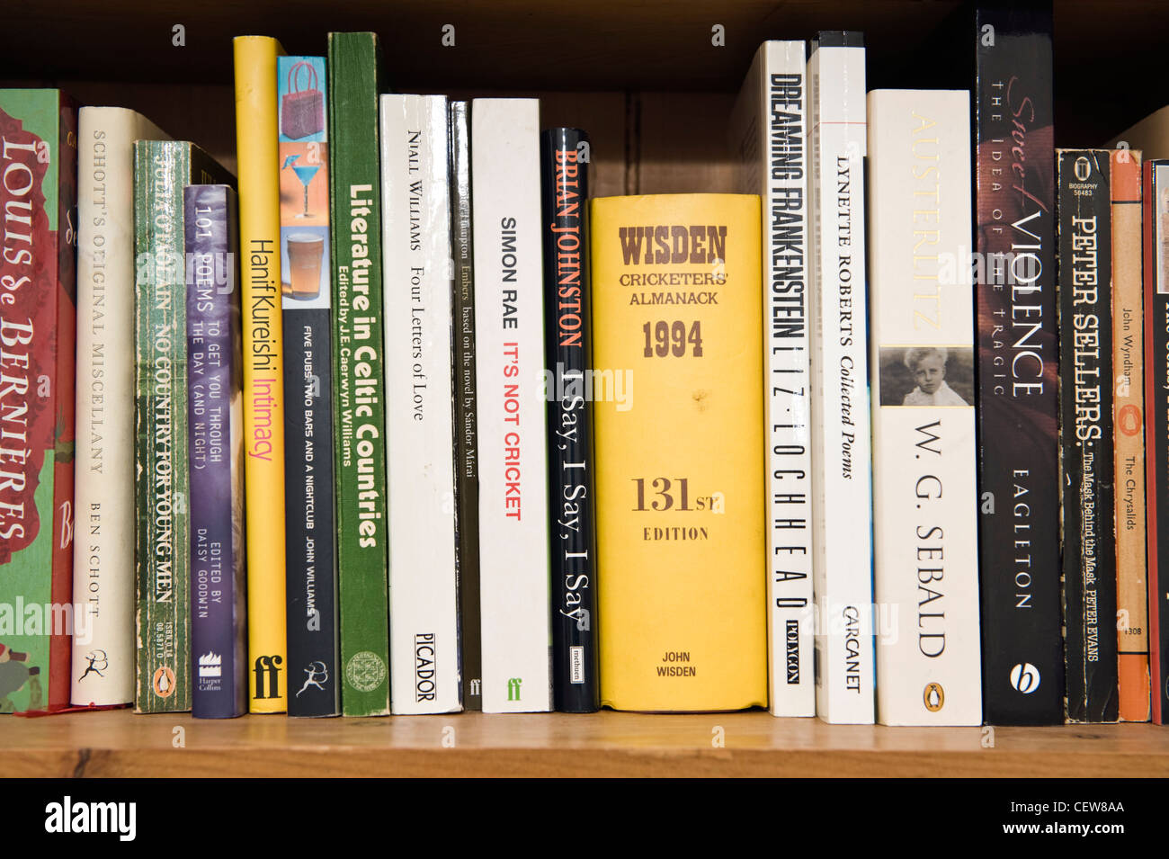 Selezione di libri sullo scaffale compresi WISDEN cricket almanack Foto Stock