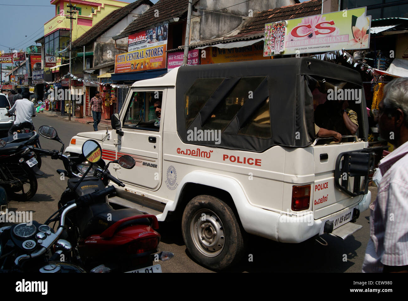 Polizia petrolling Jeep attraverso la congestionata Chalai Bazar Market Road nella città di Trivandrum,Kerala, India Foto Stock